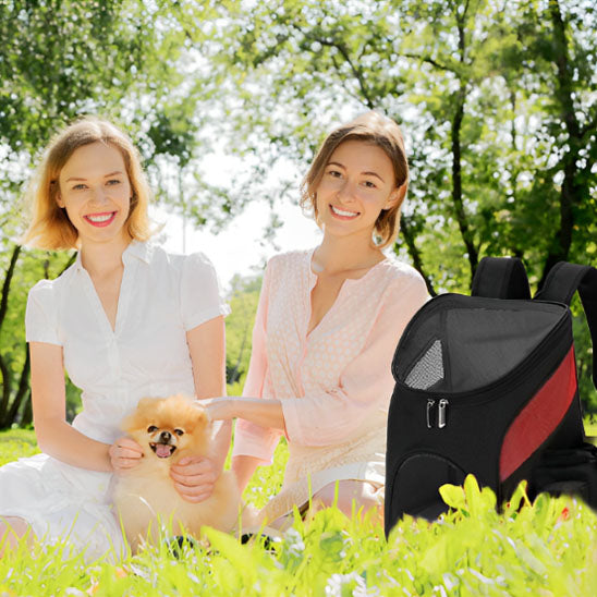 Deux femmes avec un chien dans un jardin avec le sac de transport noir et rouge