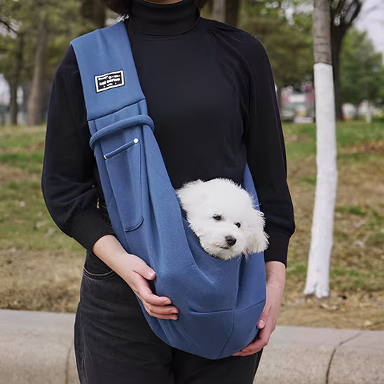 Chien dans un sac de transport bleu en bandoulière