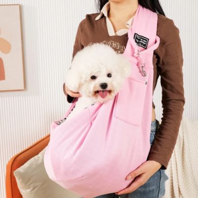 Chien dans un sac de transport rose en bandoulière tout heureux d'être avec sa maîtresse