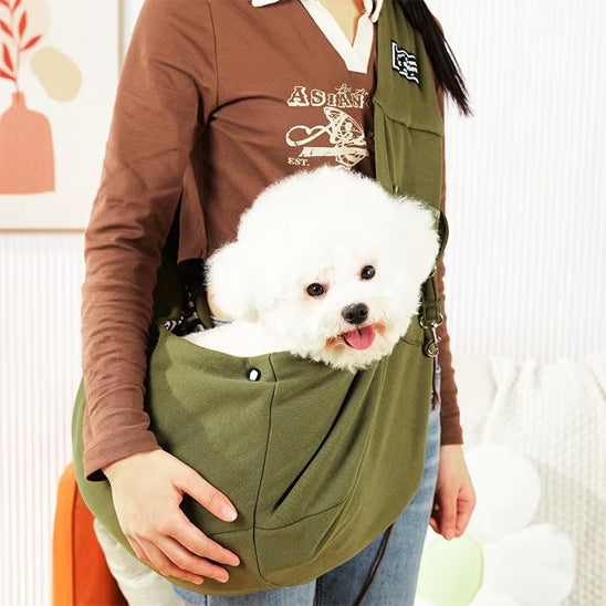 Jeune fille avec son chien dans un sac de transport vert en bandoulière à la maison