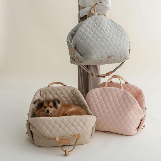 Trois sacs de transport, rose, brun,et gris avec une femme qui tient le gris et un petit chien assis à l'intérieur du brun