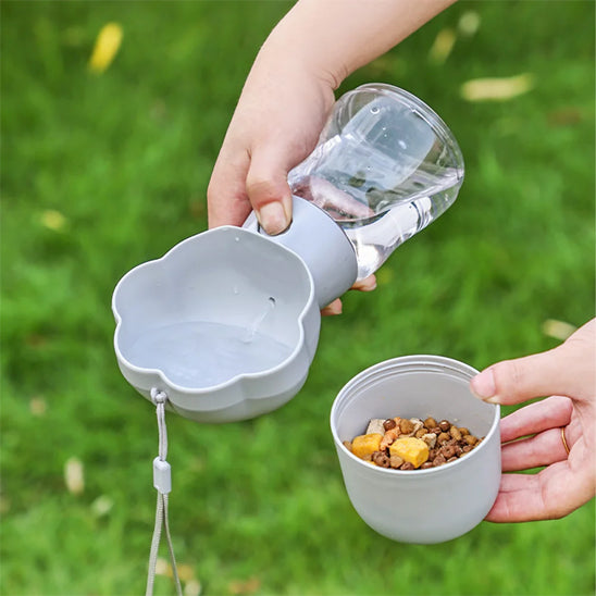 Gourde pour chien grise avec compartiment croquettes utilisées dans un parc pour rafraîchir un petit chien actif